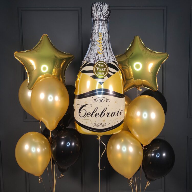 Композиция черных и золотых шаров с золотой бутылкой шампанского